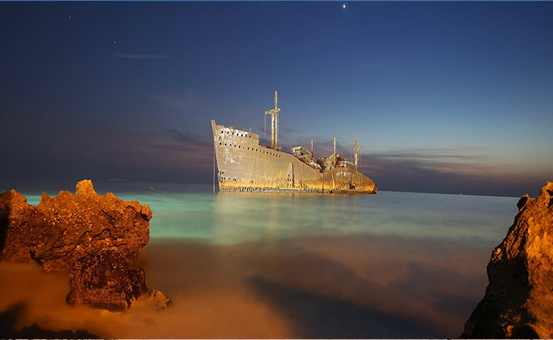 کشتی یونانی و تماشای غروب با پس زمینه آن